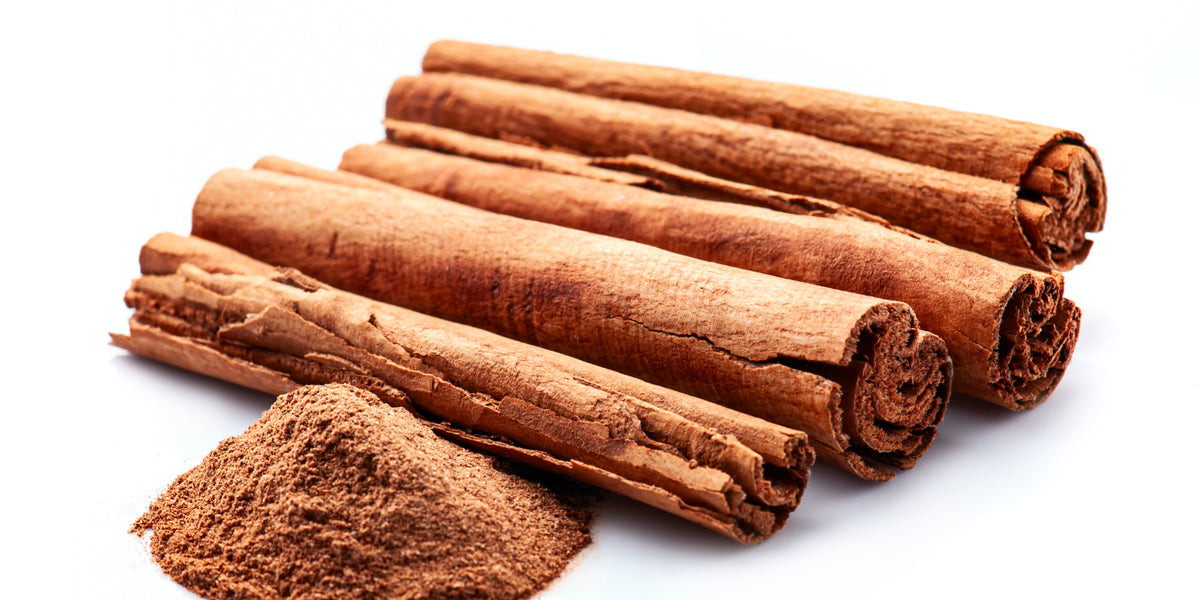 Cinnamon for Mood, Metabolism & Women’s Health from Wile. ID: 4 tightly coiled cinnamon sticks  and a small mound of ground cinnamon on a white background
